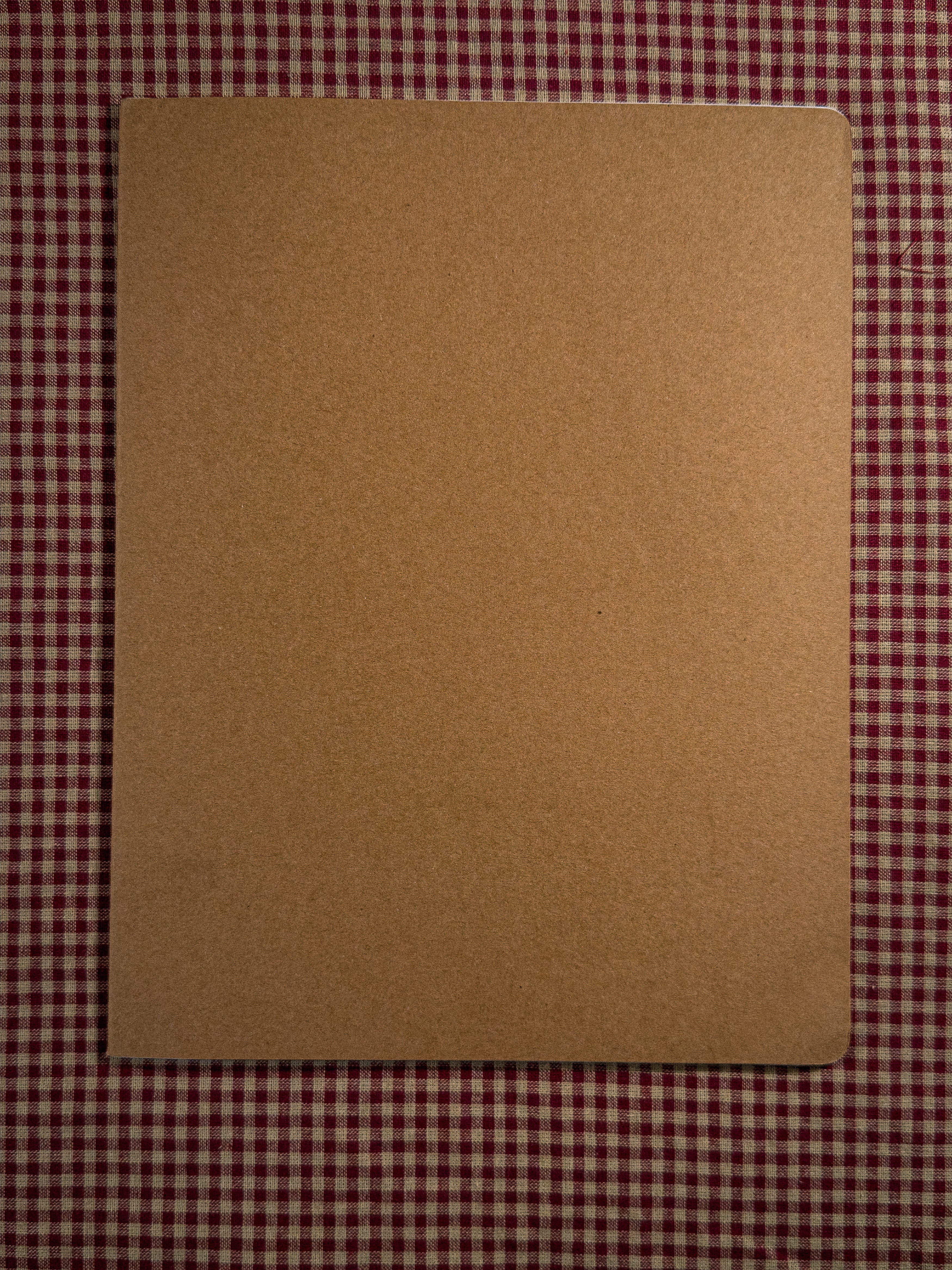 A brown a4 desk sized paper notebook sized at 11" x 8.5" 