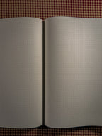 A brown a4 desk sized paper notebook sized at 11" x 8.5" laying open