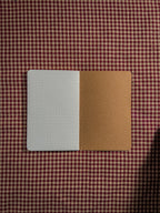 A small brown pocket sized paper notebook sized at 3" x 5.5" open flat
