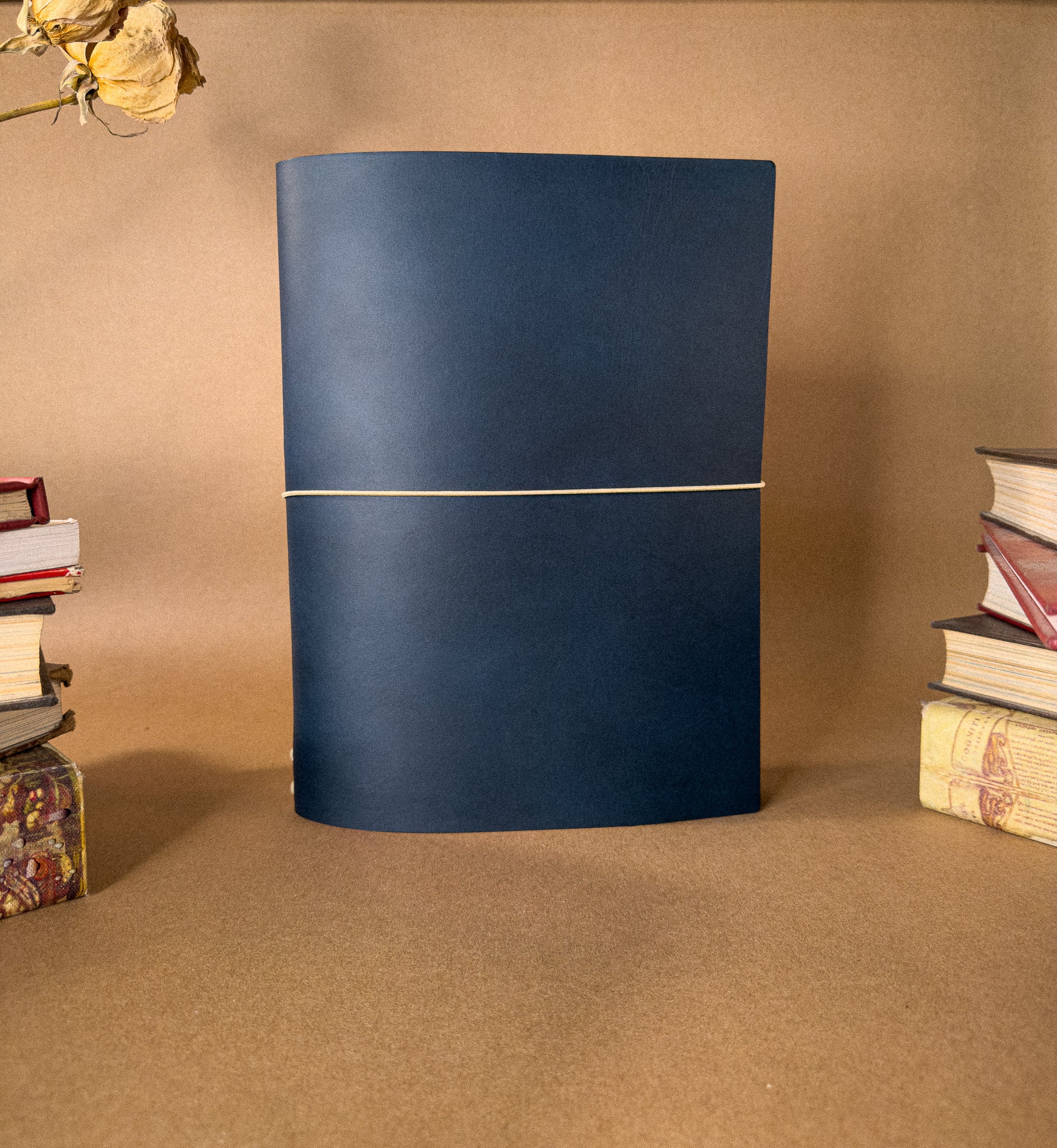 A Large Blue desk sized leather Journal on a beige backround