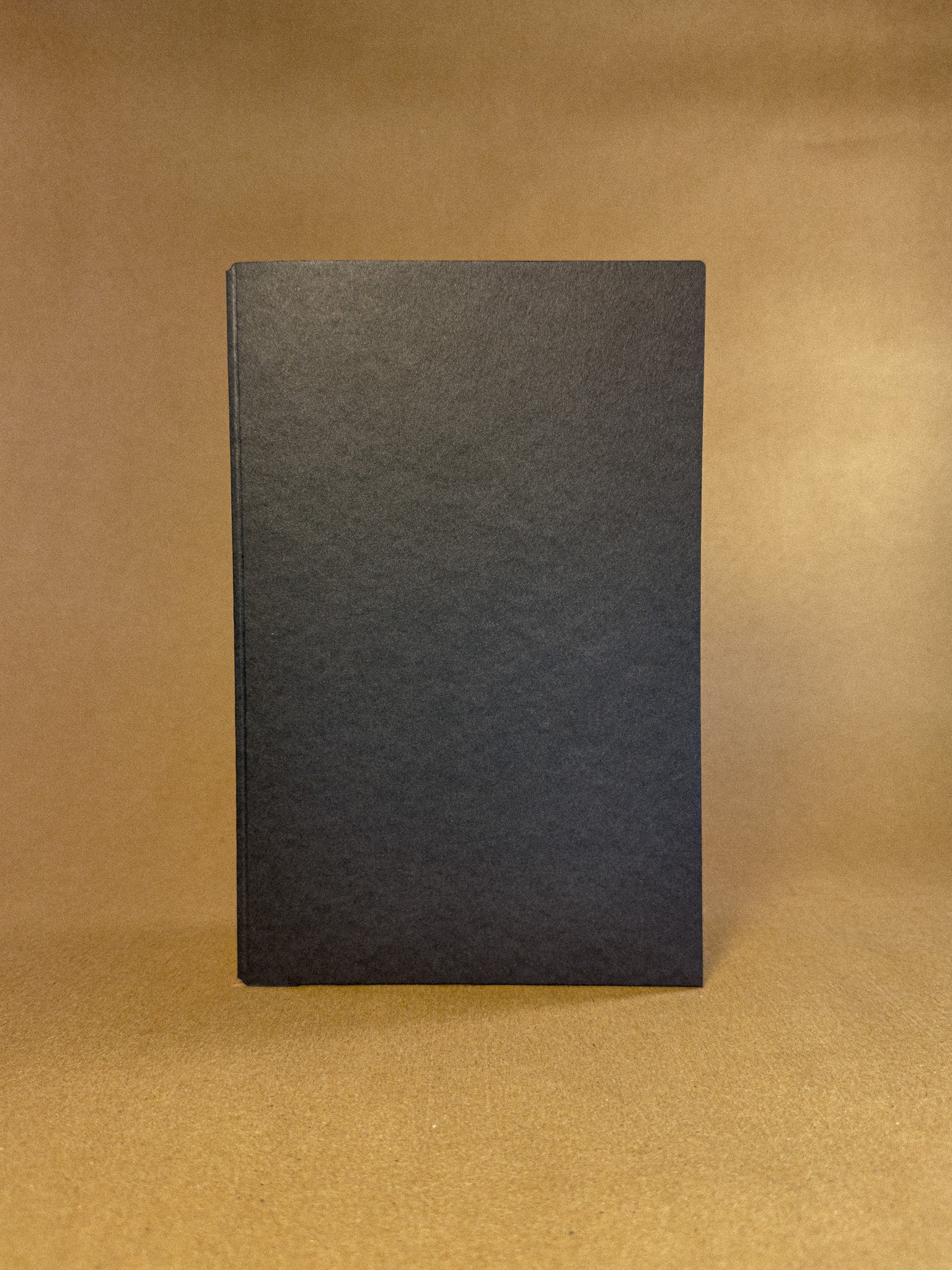 A black paper folder in The Chronicle Book bag journal sizing 
