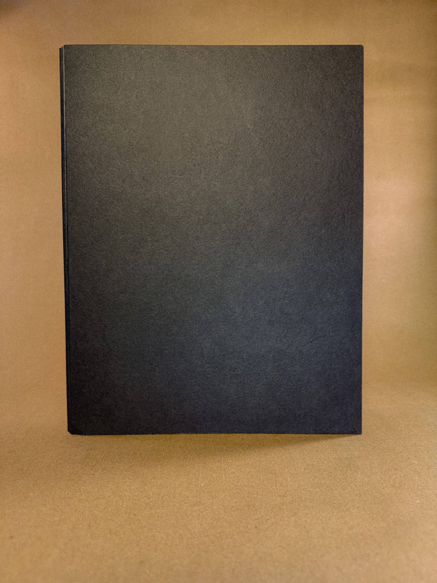 A black paper folder in The Archive Desk journal sizing 